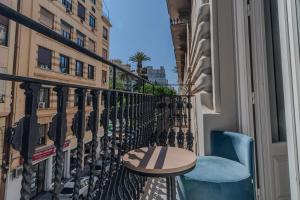 a balcony with a table and a chair and a window at Soho Boutique Turia in Valencia