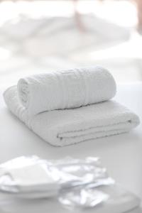 a stack of white towels on a table with scissors at Hemera House Fourka in Fourka