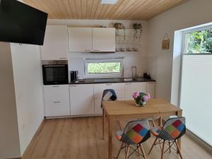 a kitchen with a table and chairs and a table and a window at Honey house in Zgornje Gorje