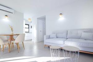 a living room with a white couch and a table at Linda Vista Beach Apartment in Marbella