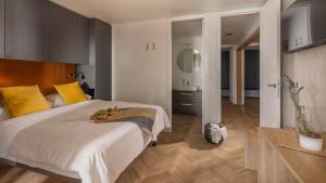 a bedroom with a large white bed with yellow pillows at Terra Park Phalaris in Novalja