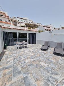 a patio with chairs and tables on a building at Alojamientos Agaete Pueblo Nº14 in Agaete