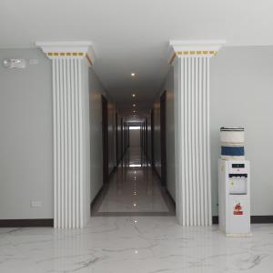 an empty hallway with columns in a building at Hotel NaeR in Romblon