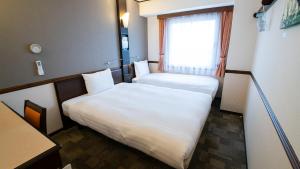 Postel nebo postele na pokoji v ubytování Toyoko Inn Hikone eki Higashi guchi
