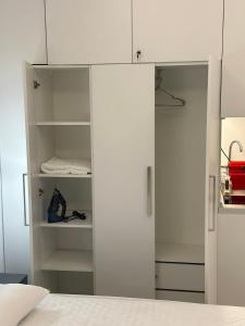 a white wardrobe in a room with a bed at Peraia Luxury Studio in Perea
