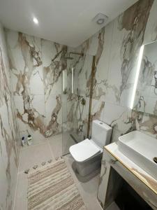 a bathroom with a toilet and a sink at Peraia Luxury Studio in Perea +22 photos
