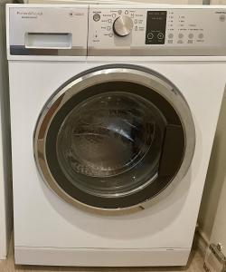 a white washing machine sitting in a kitchen at A city oasis - full apartment with balcony in Perth