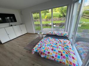 a bedroom with a bed and a large window at Helle, moderne Wohnung im Grünen in Kürten