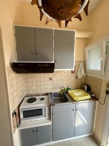 Una pequeña cocina con fregadero y microondas. en Telis apartments, en Rodas