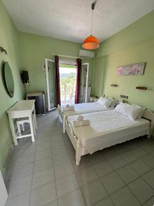 Un dormitorio grande con dos camas y una mesa. en Telis apartments, en Rodas
