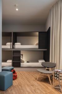 a living room with a room with bunk beds at TOC Hostel Malaga in Málaga