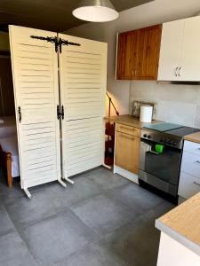 a kitchen with white doors and a stove top oven at Nicole's Cave Studio in Pylos