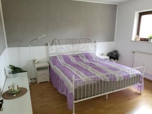 une chambre avec un lit avec une couette violette dans l'établissement Ferienwohnung Mosel Hunsrück, à Moritzheim