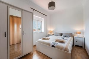 1 dormitorio blanco con 1 cama grande y 2 lámparas en Fantastic home in Bustelo, en Oliveira de Azemeis