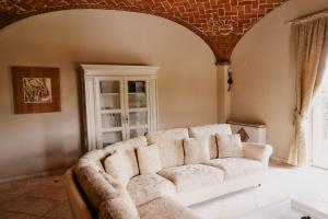 a living room with a white couch and a window at Tenuta Montemagno Relais & Wines in Montemagno