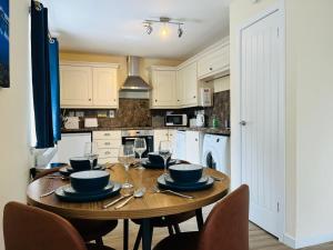 a kitchen with a wooden table with wine glasses at Marina Apartments 2 in Fort William