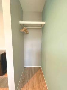 a walk in closet with a white shelf and wood floors at Urban Resort Villa ILILANI in Inbu