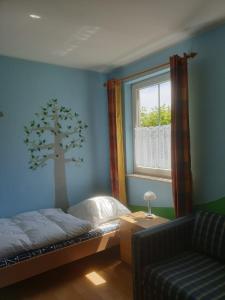 a bedroom with a bed and a tree painted on the wall at charmantes Ferienhaus ruhig gelegen für 6 Personen in Welzin