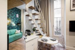 a living room and a kitchen with a spiral staircase at Nid douillet parisien in Paris