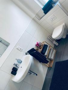 a white bathroom with a sink and a toilet at Apartment Charly in Steinbeck in Recke