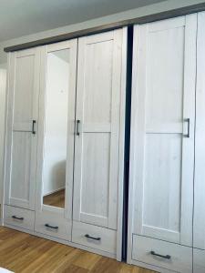 un armario blanco con dos puertas y un espejo en Apartment Charly in Steinbeck, en Recke