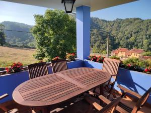 una mesa de madera y sillas en un balcón con vistas en VILLA ACEBO, en Arboleya