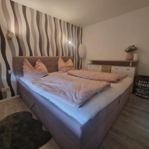 a bedroom with a large bed with white sheets at Ferienhaus Lion in Neustadt-Glewe +11 photos