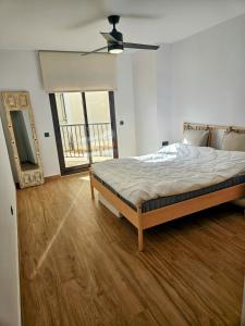 ein Schlafzimmer mit einem Bett und einem großen Fenster in der Unterkunft Luxury 3 bed apartment Marina de la Duquesa, huge terrace pool views, 500 meters to Beach in Manilva + 70 Fotos