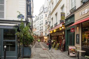 a city street with people walking down the street at Nid douillet parisien in Paris
