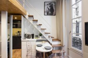 a kitchen and dining room with a table and a staircase at Nid douillet parisien in Paris