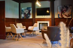 a room with chairs and a fireplace and a tv at Haus Elim für Gruppen und Großfamilien in Heringsdorf