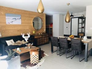 ヴォジャニーにあるAppartement Cocooning-sauna-jacuzziのテーブルとダイニングルームのあるリビングルーム