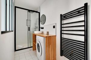 ein Badezimmer mit einer Waschmaschine und einem Spiegel in der Unterkunft Charming studio A-C - 2P - Le Marais in Paris