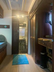 Un pasillo de una habitación con una puerta con una alfombra azul. en Silver Bullet Spa, en Londres