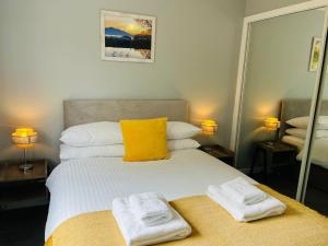 een slaapkamer met een bed met twee handdoeken erop bij Marina Apartments 3 in Fort William