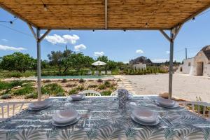 Una mesa con platos encima en la playa. en Brunaldi Trulli by Perle di Puglia, en Martina Franca