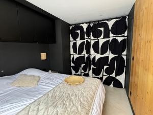 a bedroom with a bed with a black and white wall at Appartement F2 Bis centre de Megève in Megève