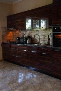 a kitchen with wooden cabinets and a sink and a microwave at Villa Aragvi in Mtskheta