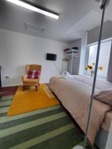 a bedroom with a bed and a chair and a window at Chic Studio Near Cardiff Hub in Cardiff