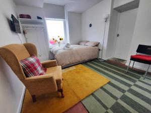 a bedroom with a bed and a chair and a window at Chic Studio Near Cardiff Hub in Cardiff