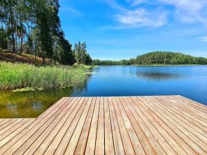 a wooden dock sitting on top of a lake at Sofijos Slėnis in Pakniškiai +33 photos