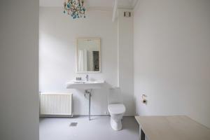 a white bathroom with a toilet and a sink at Super Central 2BR Apartment in Old Town Copenhagen in Copenhagen