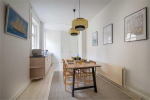 a kitchen with a table and a small kitchen with a counter at Super Central 2BR Apartment in Old Town Copenhagen in Copenhagen