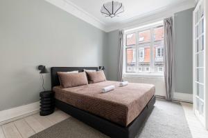 a bedroom with a bed and a window at Super Central 2BR Apartment in Old Town Copenhagen in Copenhagen