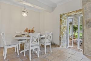 a white dining room with a white table and chairs at La Casuca del Músico in Novales