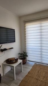 a living room with a large window with a flat screen tv at Casa AltaVista Guanaqueros in Guanaqueros