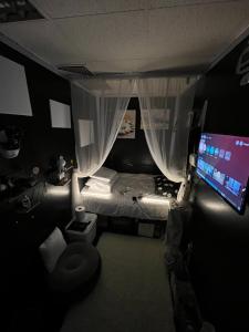 a small room with a bed and a television at Managa-naga Room1204 near abu dhabi mall in Abu Dhabi