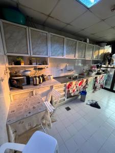 a kitchen with wooden cabinets and a white tiled floor at Managa-naga Room1204 near abu dhabi mall in Abu Dhabi +1 photo