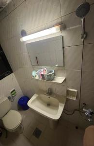 a bathroom with a sink and a toilet and a mirror at Managa-naga Room1204 near abu dhabi mall in Abu Dhabi