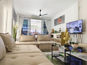 a living room with a couch and a tv at Beach Villa NA JOMBTIEN ROOF TOP in Na Jomtien